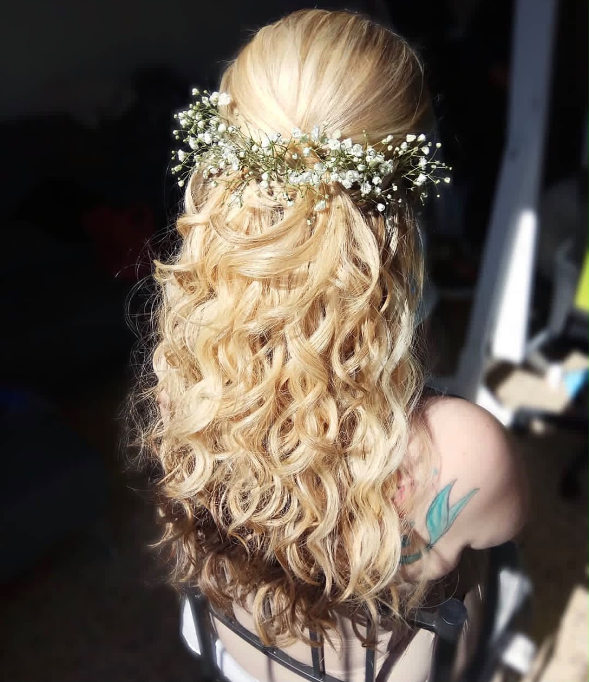 Bridal hair by Lee Elrom — half-up blonde curls with a baby's breath crown